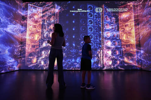 visitors in front of a digital wall of sound